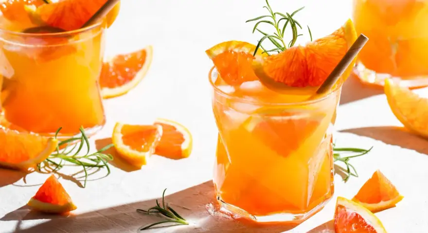 Erfrischender, fruchtiger Gin Cocktail mit Orangenscheiben und Rosmarin. Perfekt für einen sonnigen Tag.