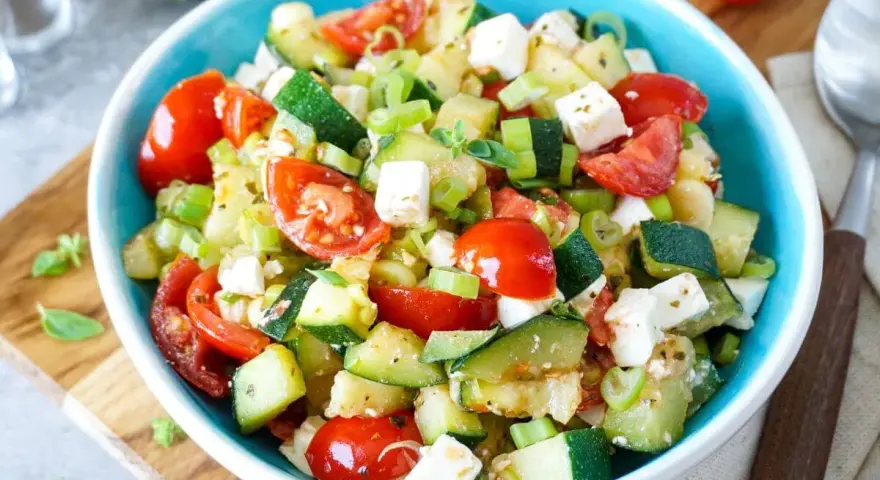 Erfrischender Zucchini Salat mit Tomaten und Feta. Ein leichtes Rezept für heiße Tage.