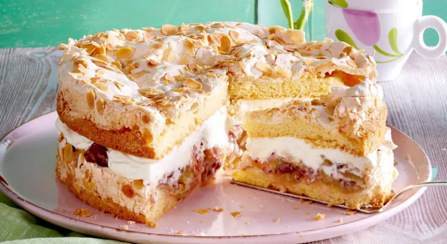 Stachelbeertorte Landfrauen: saftiger Biskuit, cremige Füllung und knusprige Baiserhaube mit Mandeln. Ein Genuss!
