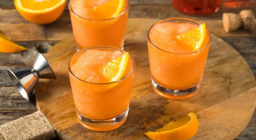 Erfrischender, gefrorener Aperol mit Orangenspalten, bereit für einen heißen Sommertag.