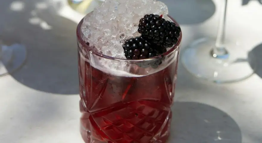 Erfrischender Brombeer-Cocktail mit zerstoßenem Eis und frischen Beeren. Perfekt für sommerliche longdrink rezepte.