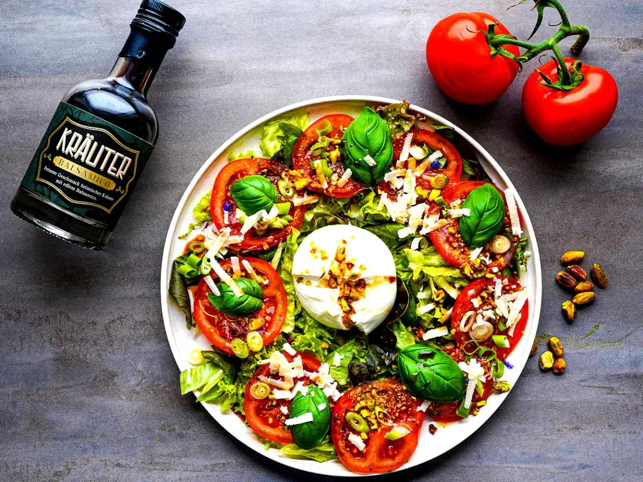 Ein frischer Tomatensalat mit cremiger Burrata, garniert mit Basilikum und Balsamico.
