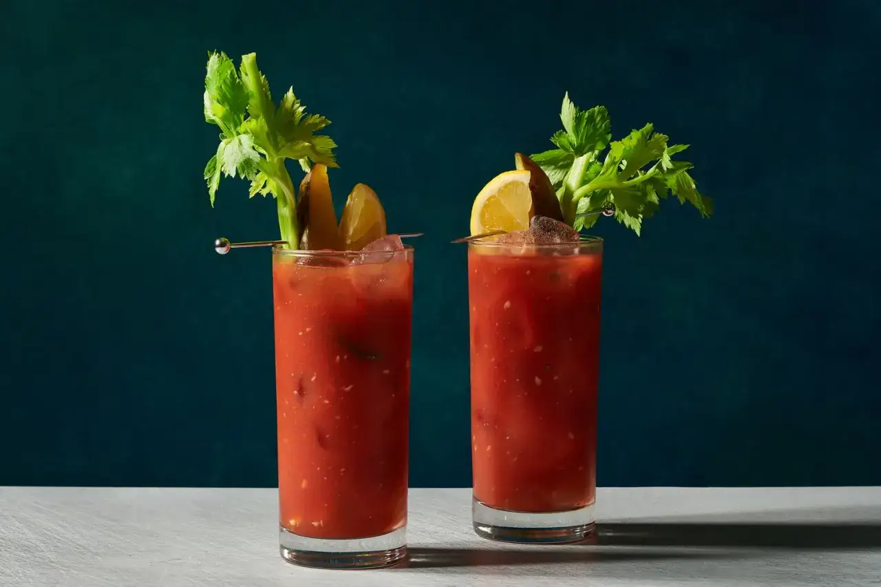 Zwei Gl&auml;ser mit mexikanischem Tomatensaft, garniert mit Sellerie, Gurken und Zitrone.