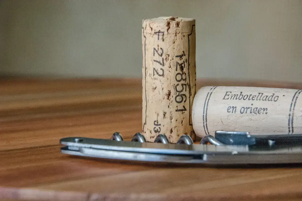 Zwei wein verkorkt Korken und ein Kellnermesser liegen auf einem Holztisch.
