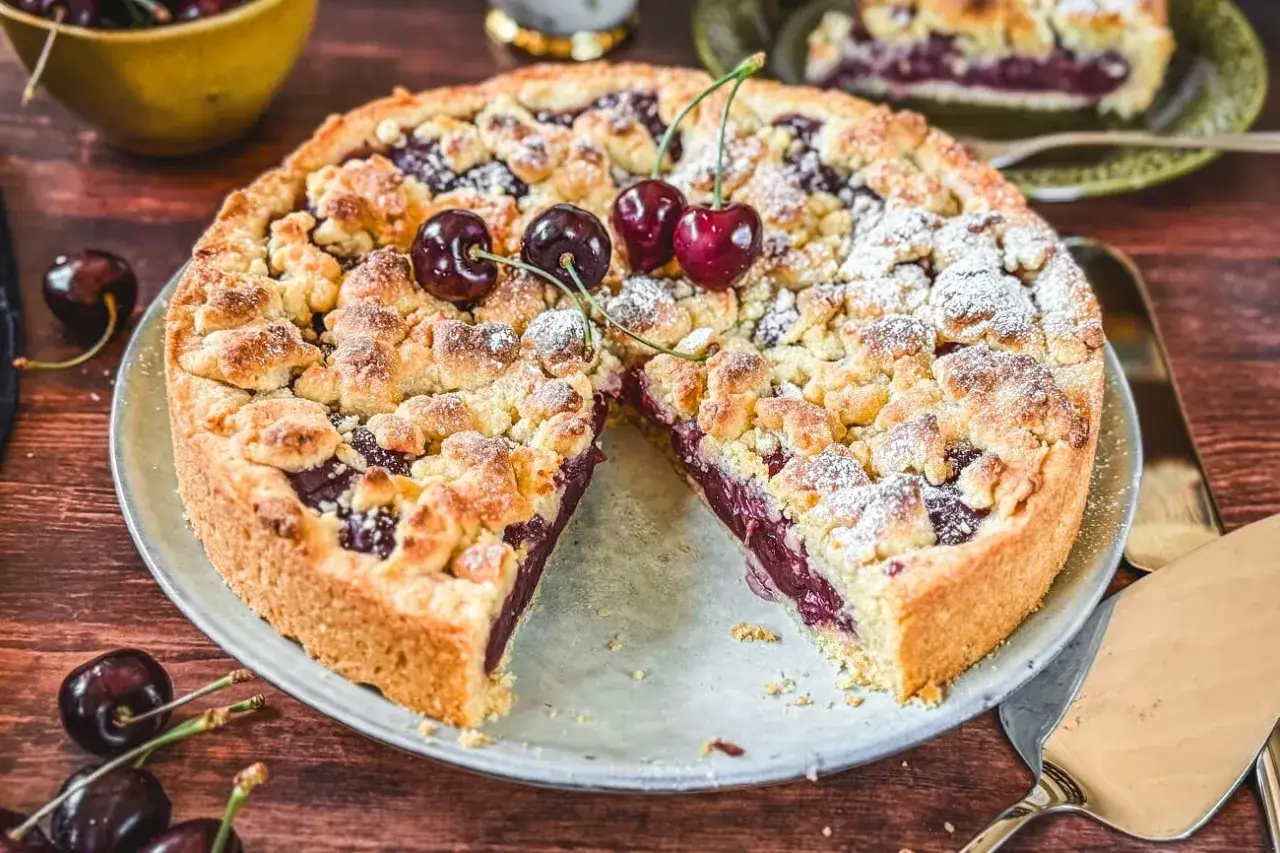 Ein Kirschkuchen mit Streuseln, der zeigt, wie man Streusel macht. Mit frischen Kirschen und Puderzucker best&auml;ubt.