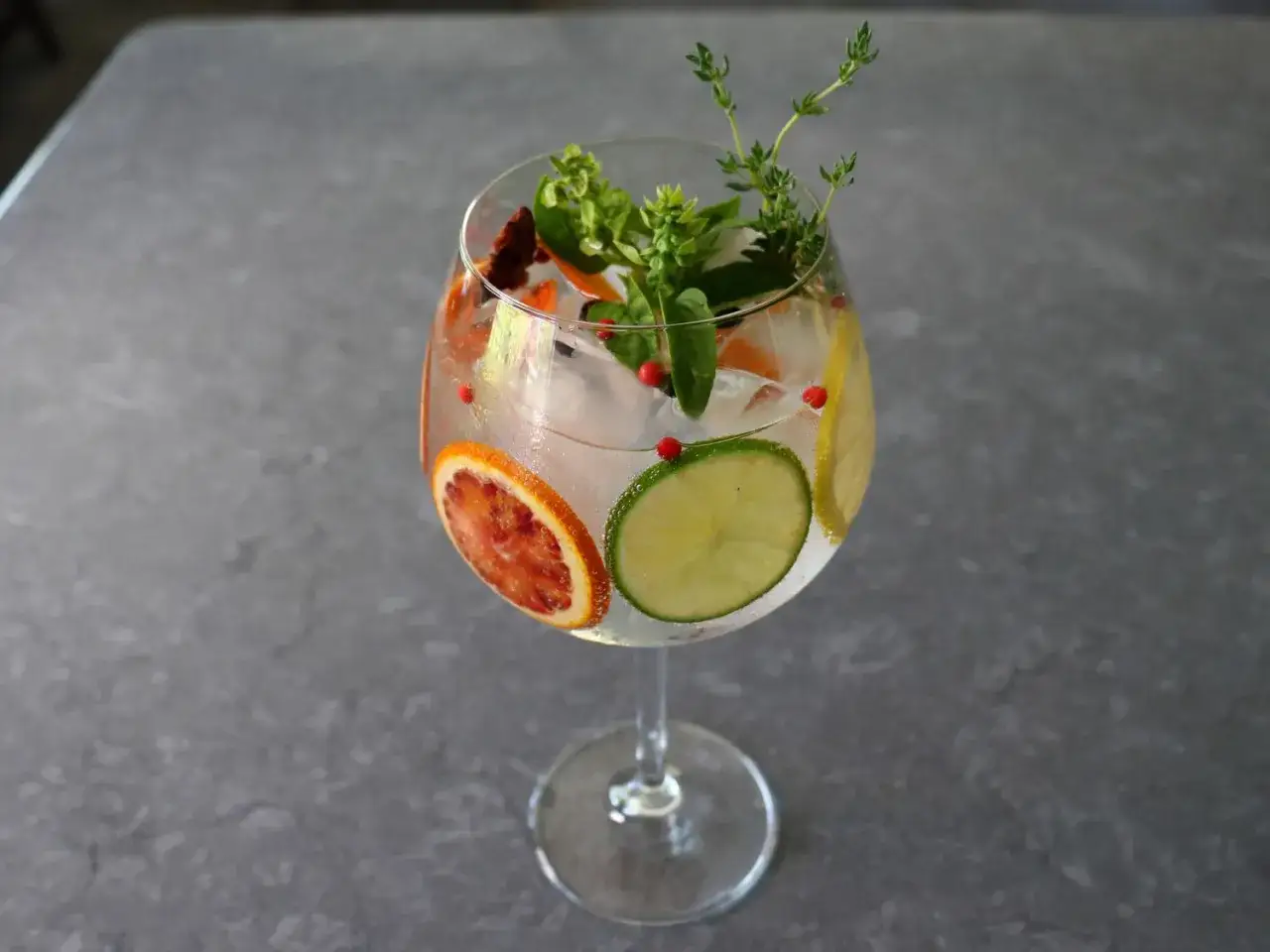 Erfrischender Gin Mix mit Blutorange, Limette, Zitrone, Kr&auml;utern und rosa Pfefferbeeren.