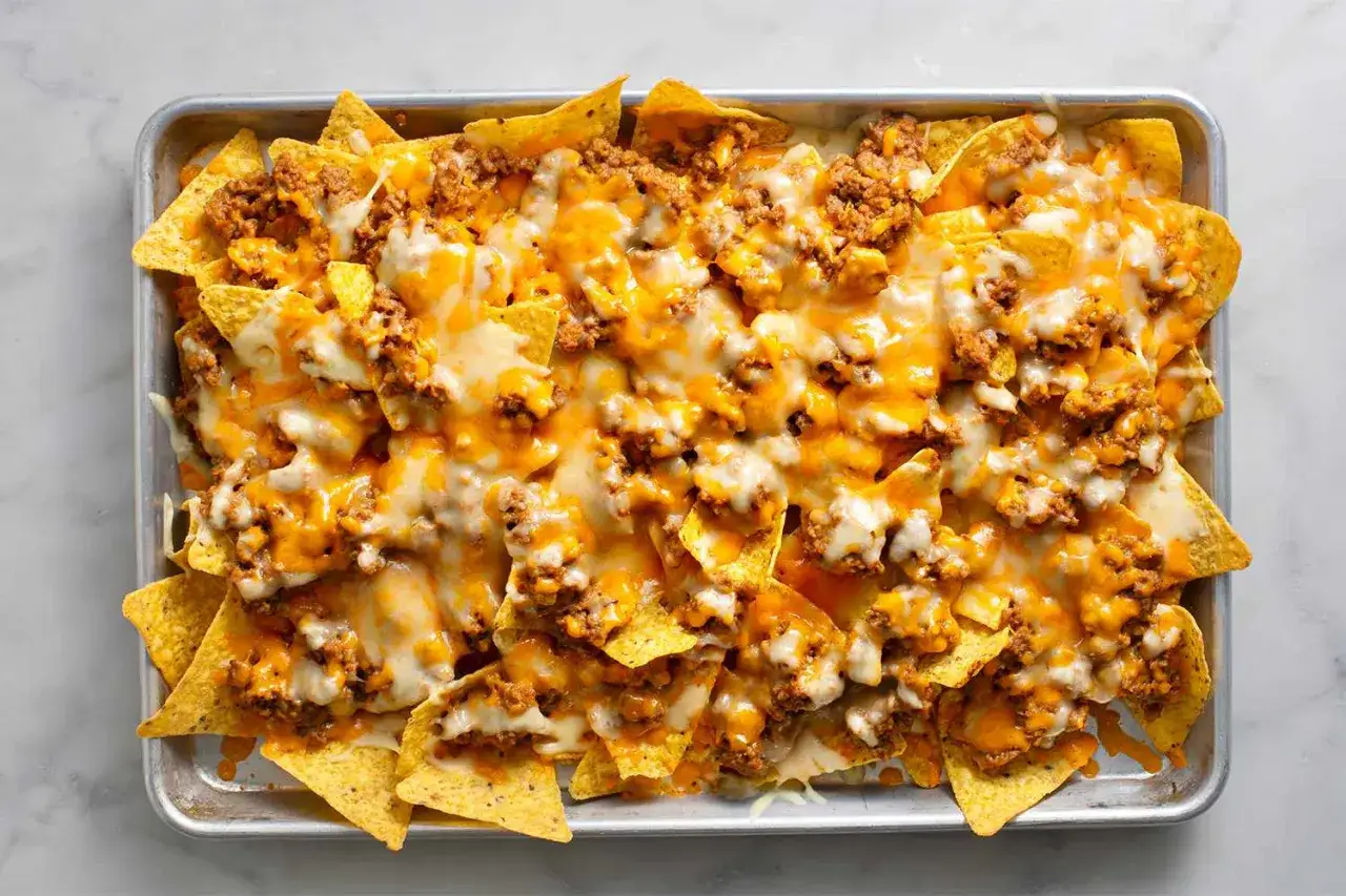 Ein Blech mit einem k&ouml;stlichen, geschmolzenen K&auml;se-Nacho-Auflauf, belegt mit Hackfleisch.