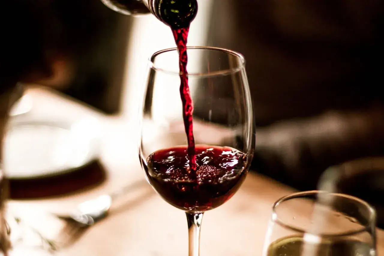 Rotwein flie&szlig;t in ein Glas. Der intensive Duft von Cabernet Sauvignon Geschmack verspricht ein vollmundiges Erlebnis.