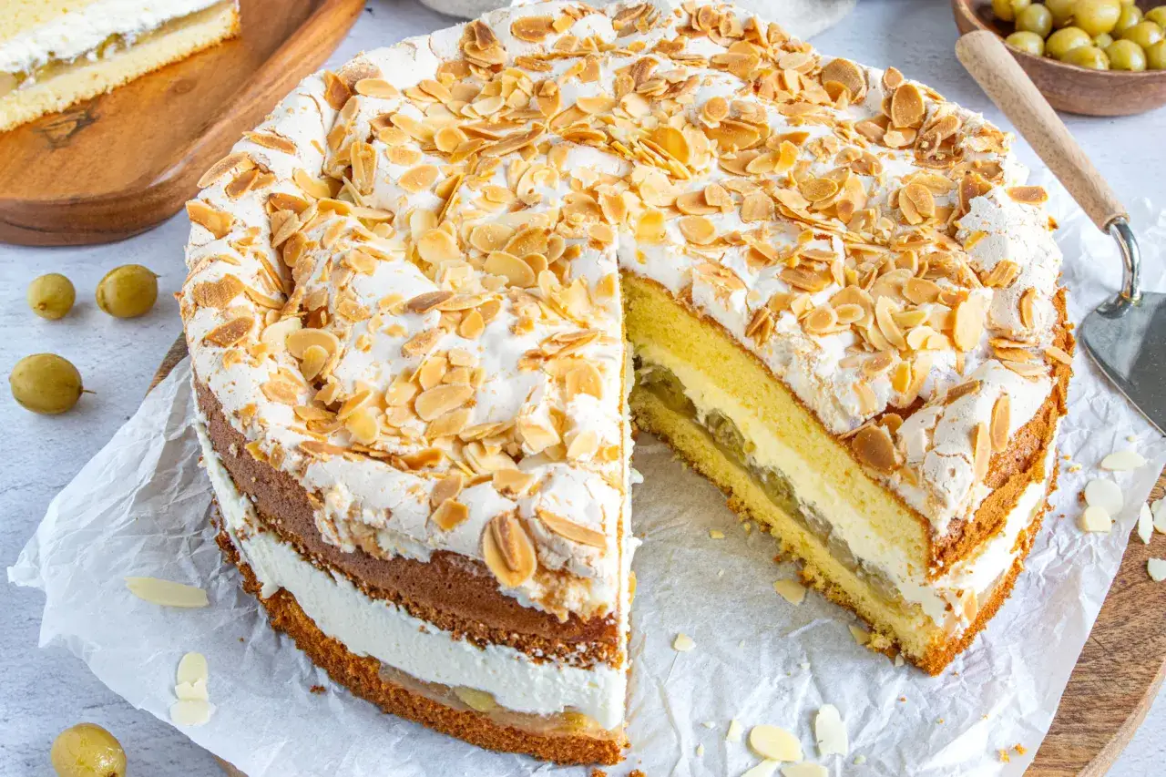 Stachelbeertorte, wie sie Landfrauen backen: Biskuit, Sahne und Stachelbeerf&uuml;llung, gekr&ouml;nt mit Baiser und Mandelsplittern.