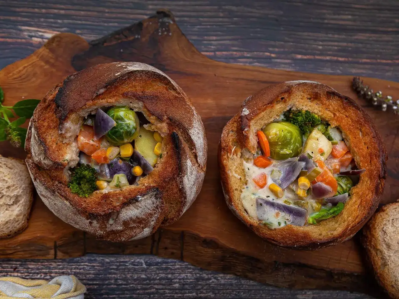 Zwei Brotschalen gef&uuml;llt mit einer cremigen Gem&uuml;sesuppe, die eine schnelle und k&ouml;stliche Mahlzeit darstellt.