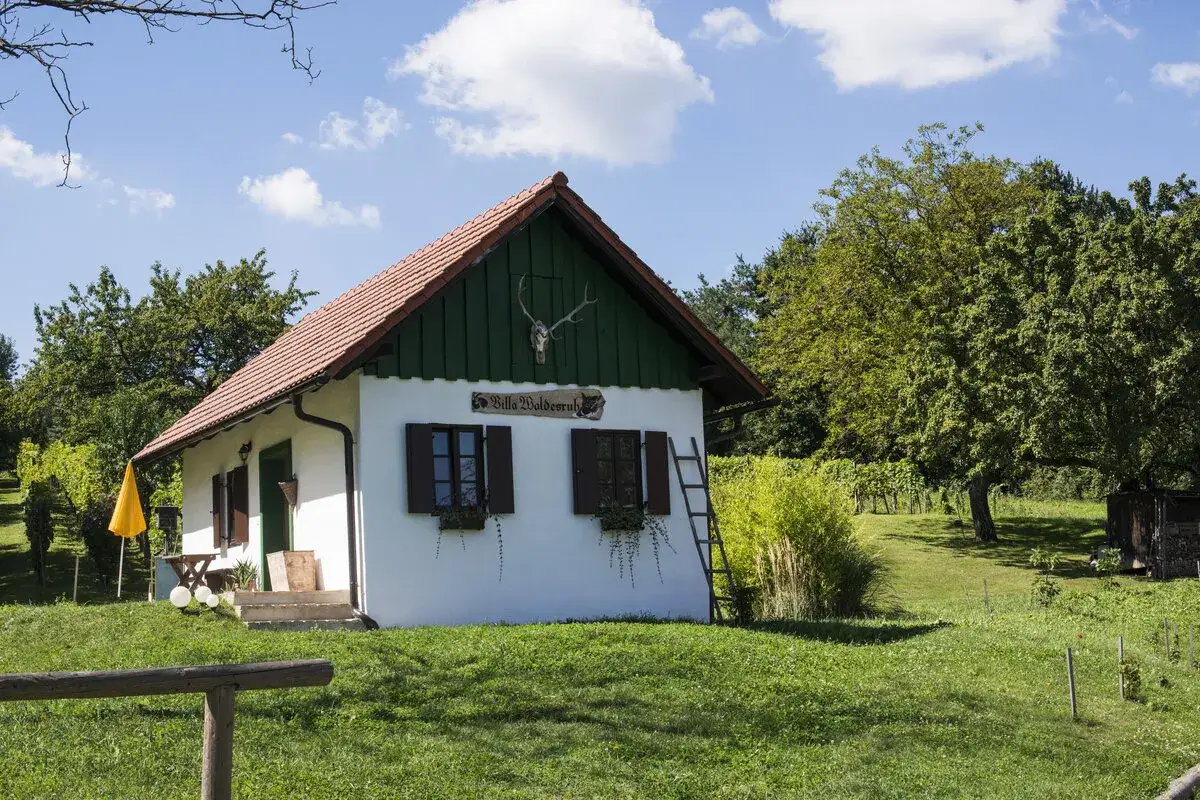 Idyllisches Haus mit Weinreben und einem Schild 