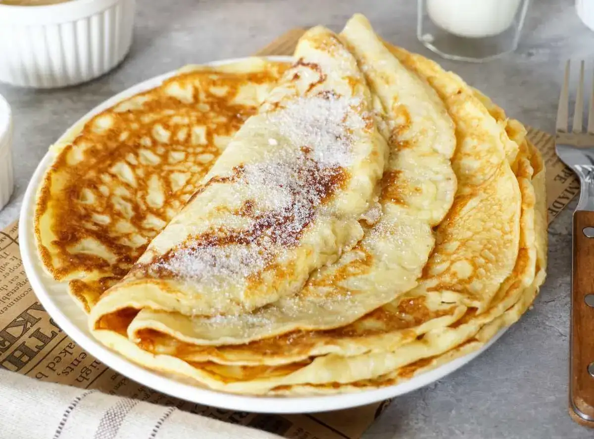 Ein Stapel Pfannkuchen, bestreut mit Zucker. Das ist das Pfannkuchen Rezept von Oma, das immer gelingt.