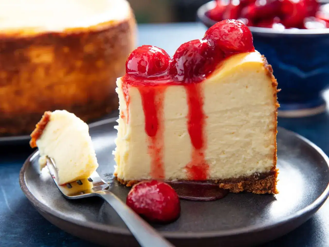 Ein St&uuml;ck cremiger American Cheesecake mit Erdbeersauce, perfekt f&uuml;r ein amerikanisches Cheesecake Rezept.