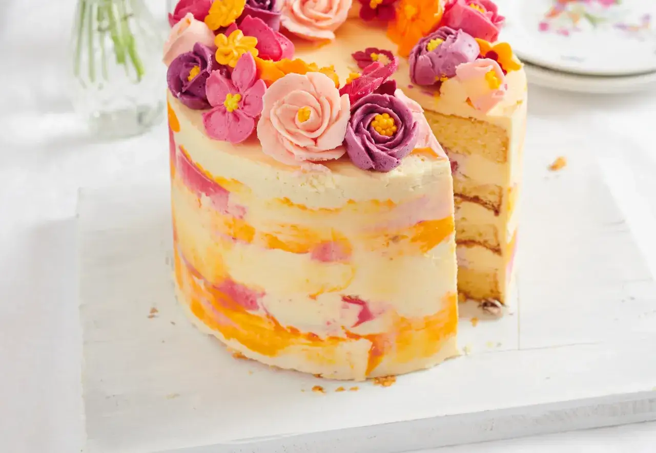 Ein bunter Kuchen mit Marmorierung und deutscher Buttercreme-Blumen.