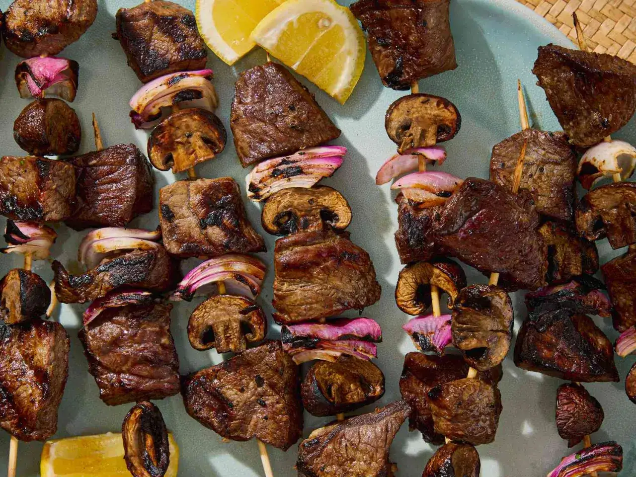 Saftige Rinder-Spie&szlig;e mit Pilzen und roten Zwiebeln, perfekt f&uuml;r ausgefallene Grillrezepte. Zitronenspalten sorgen f&uuml;r Frische.