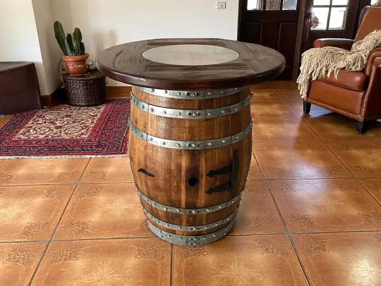 Ein Tisch aus einem Holzfass, der an Bourbon erinnert. Daneben ein Ledersessel und eine Pflanze.