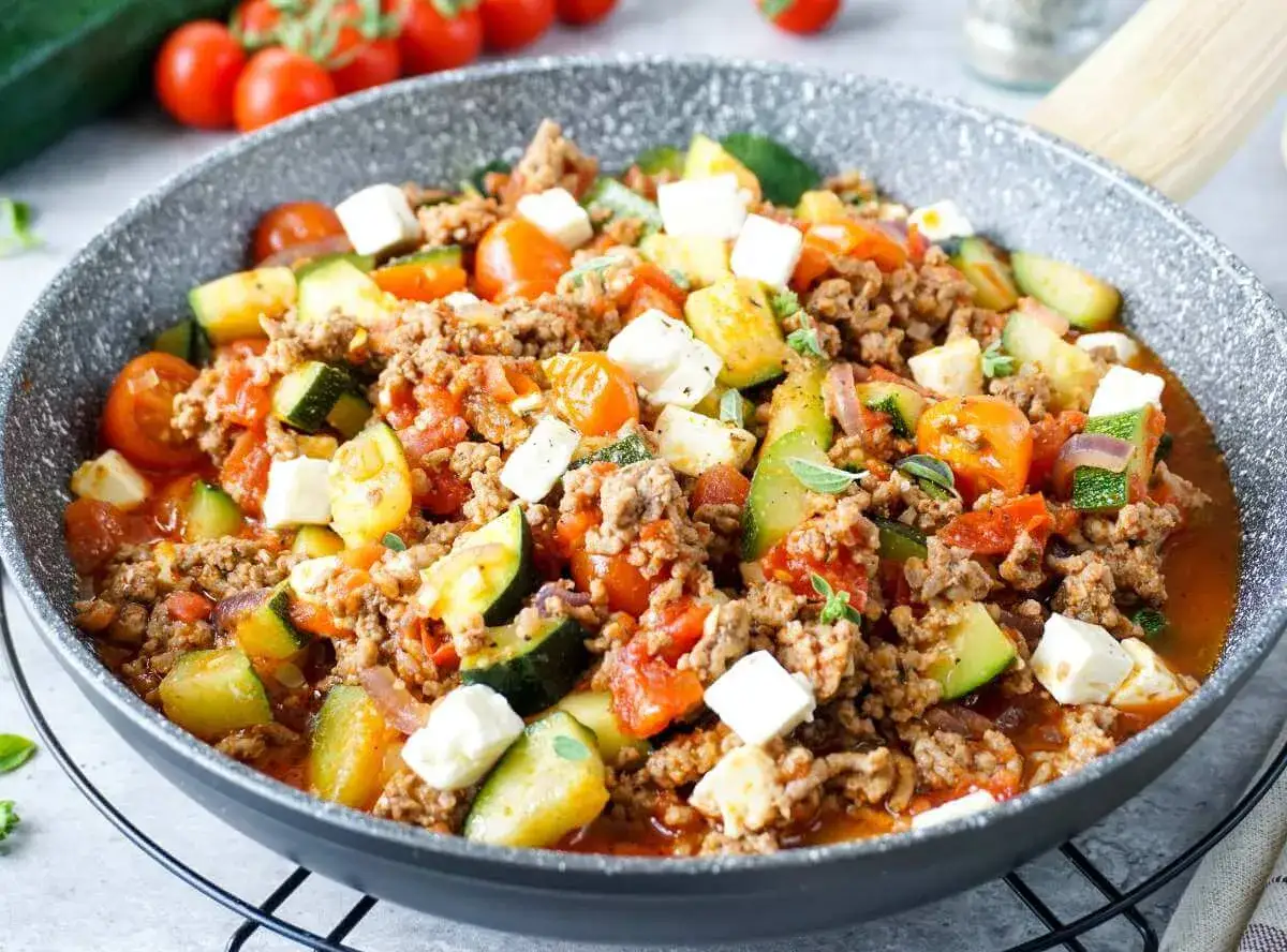 Herzhafte zucchini hackfleisch pfanne mit Tomaten und Feta, garniert mit Kr&auml;utern. Ein schnelles und leckeres Gericht.