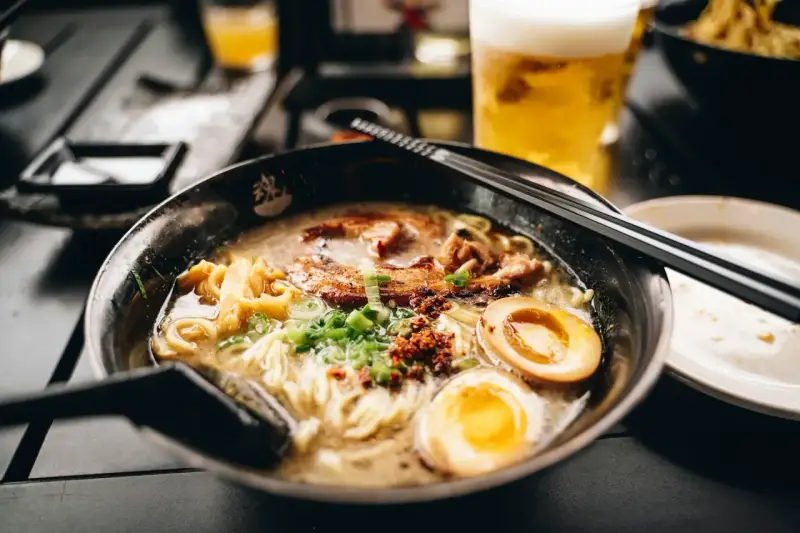 Eine dampfende Schüssel Ramen mit Nudeln, Fleisch, Ei und Frühlingszwiebeln. Das ist, was Ramen ist: ein herzhaftes japanisches Gericht.
