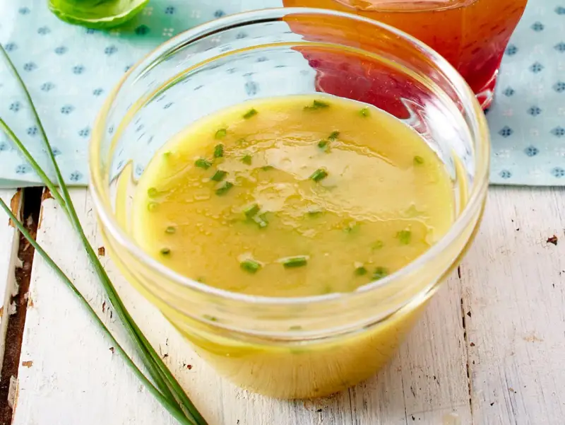 Gelbe Vinaigrette mit Schnittlauch in einer Glasschale, perfekt für frische Salat-Dressing-Ideen.